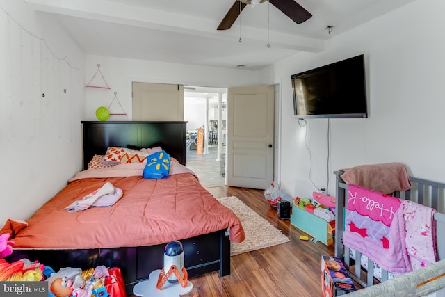 bedroom featuring hardwood / wood-style flooring, ceiling fan, and beamed ceiling