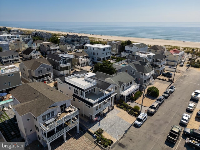 birds eye view of property featuring a water view and a beach view