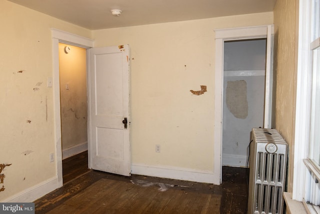 interior space with radiator heating unit and dark hardwood / wood-style flooring