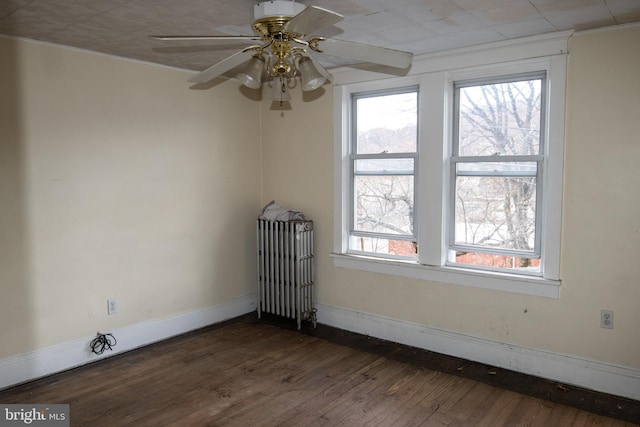 unfurnished room featuring ceiling fan, dark hardwood / wood-style flooring, and radiator