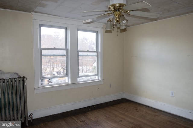 unfurnished room with ceiling fan, radiator heating unit, and dark hardwood / wood-style floors