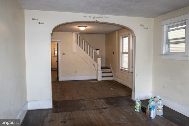 entryway with a textured ceiling and dark hardwood / wood-style floors