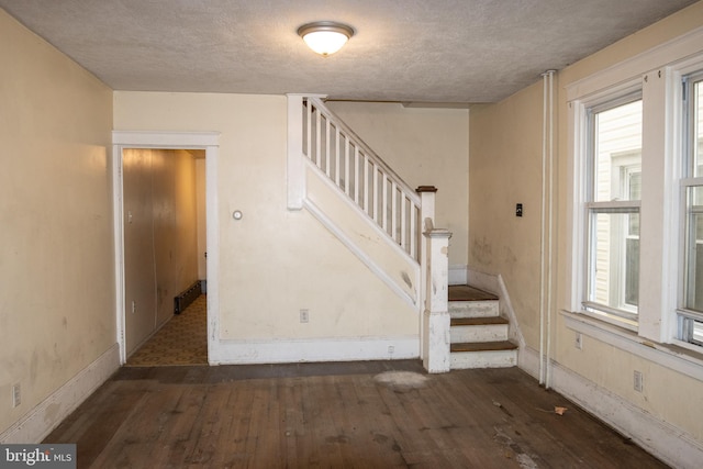 staircase featuring wood-type flooring and a textured ceiling