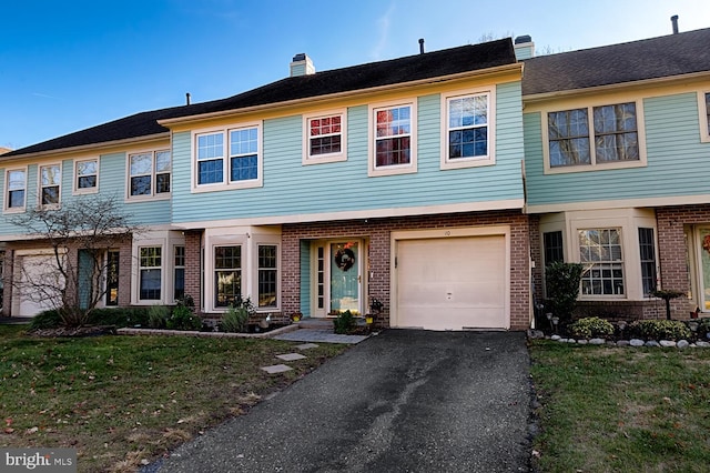 view of property featuring a garage and a front yard