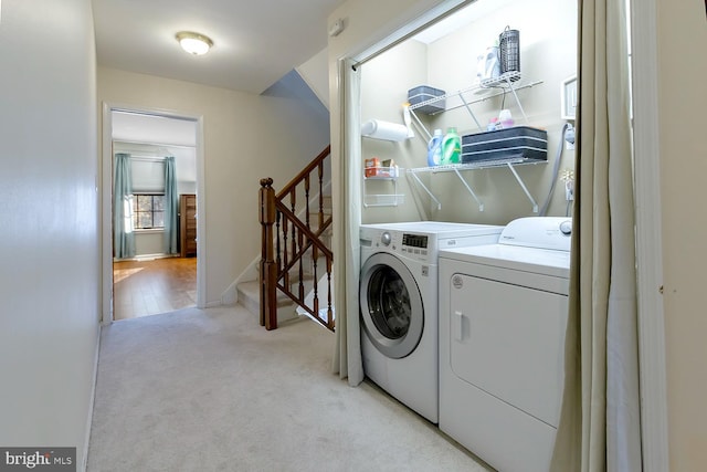 washroom featuring washer and clothes dryer and light colored carpet