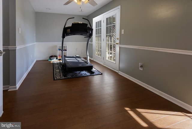 workout area with ceiling fan and dark wood-type flooring