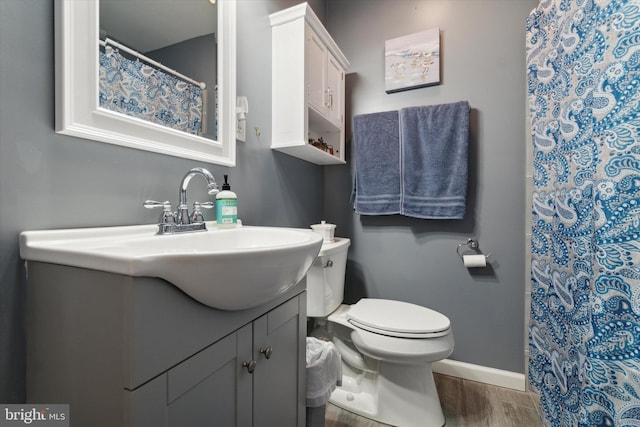 bathroom featuring wood-type flooring, vanity, and toilet