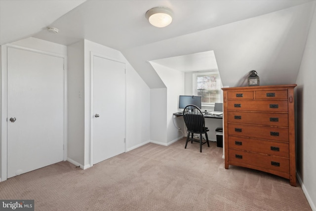 office space with light carpet and vaulted ceiling