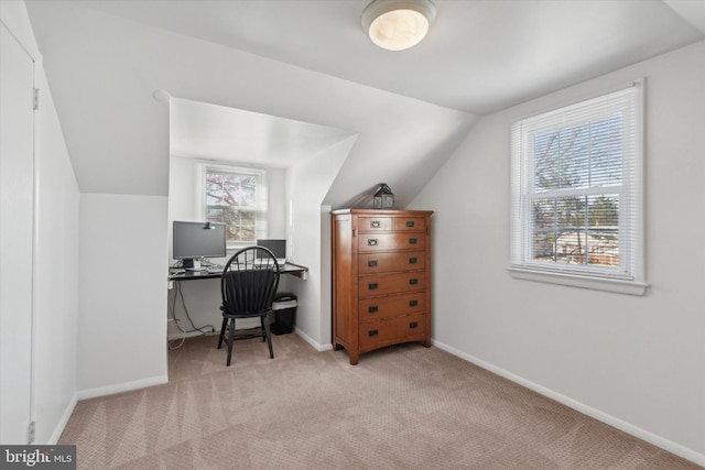 carpeted home office featuring lofted ceiling