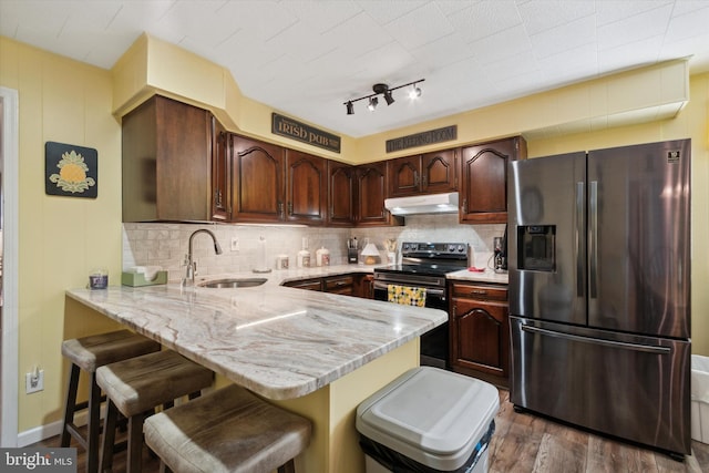 kitchen with kitchen peninsula, dark hardwood / wood-style flooring, backsplash, stainless steel appliances, and sink