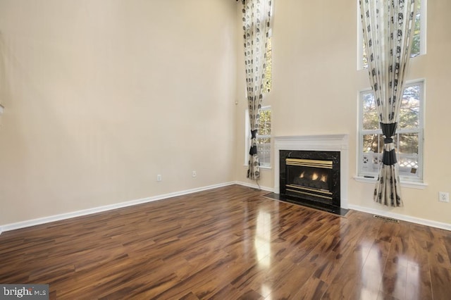 unfurnished living room with a high end fireplace and hardwood / wood-style flooring