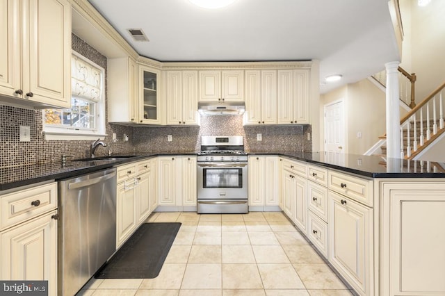 kitchen with decorative backsplash, appliances with stainless steel finishes, sink, light tile patterned floors, and cream cabinetry