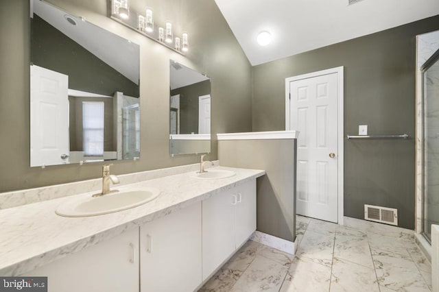 bathroom with vanity, a shower with shower door, and lofted ceiling