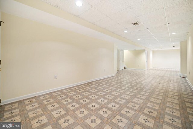 unfurnished room featuring a drop ceiling