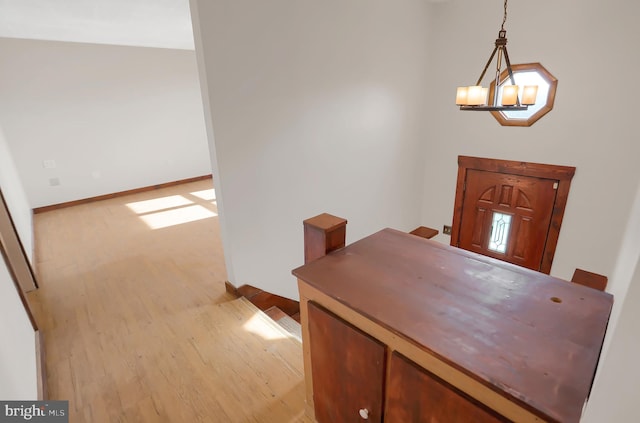 foyer entrance with light hardwood / wood-style floors and a notable chandelier