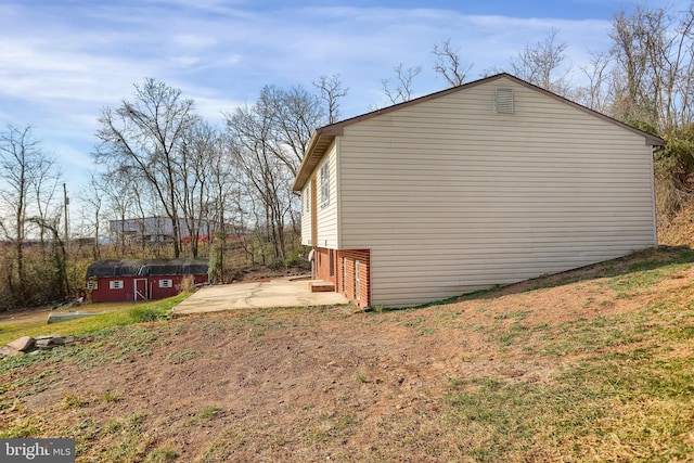 view of side of home featuring an outbuilding and a patio