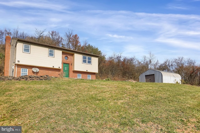 split foyer home with a garage, an outdoor structure, and a front yard