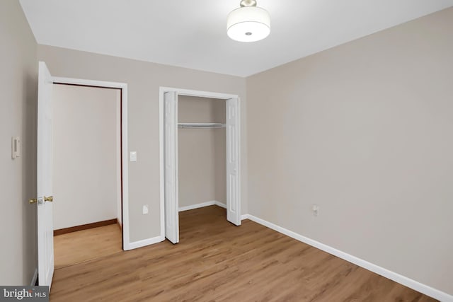 unfurnished bedroom with light hardwood / wood-style floors and a closet