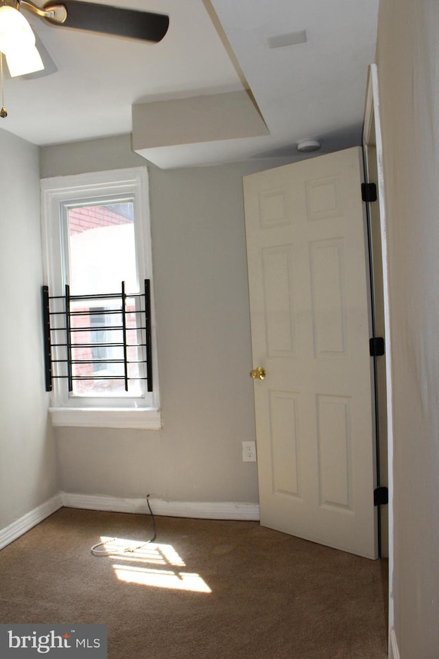 carpeted spare room featuring ceiling fan