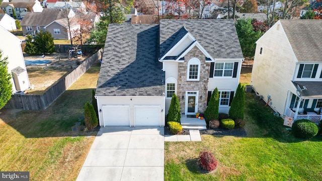 view of front facade with central AC, a front yard, and a garage