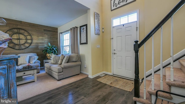 foyer entrance featuring wood walls, hardwood / wood-style floors, and a healthy amount of sunlight