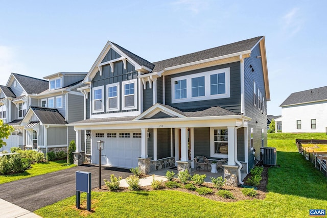 view of front facade with central air condition unit, a front lawn, a porch, and a garage