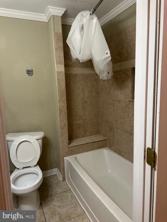 bathroom with toilet, crown molding, tiled shower / bath combo, and tile patterned floors