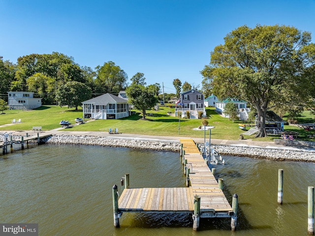 view of dock with a water view and a yard