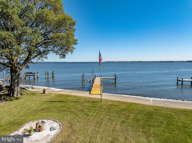 view of dock with a water view and a yard