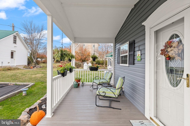 wooden deck with a yard and covered porch