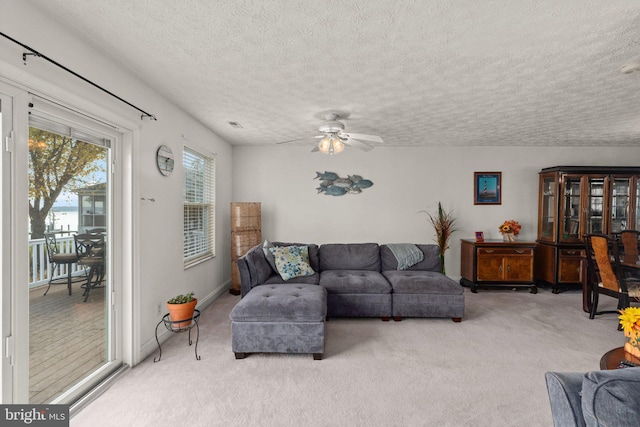 carpeted living room featuring a textured ceiling and ceiling fan