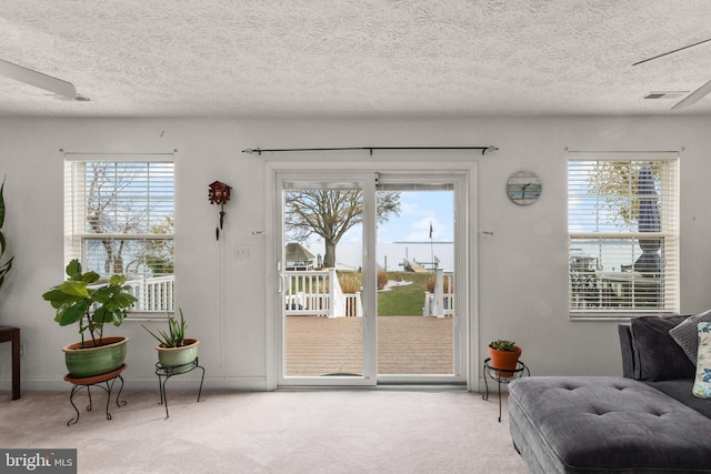 entryway with plenty of natural light and light colored carpet