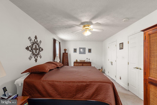 bedroom with light carpet, a textured ceiling, and ceiling fan