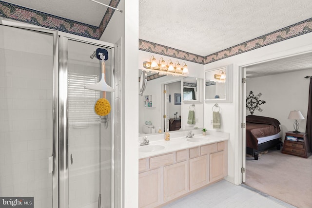 bathroom featuring vanity, a textured ceiling, a shower with shower door, and tile patterned flooring