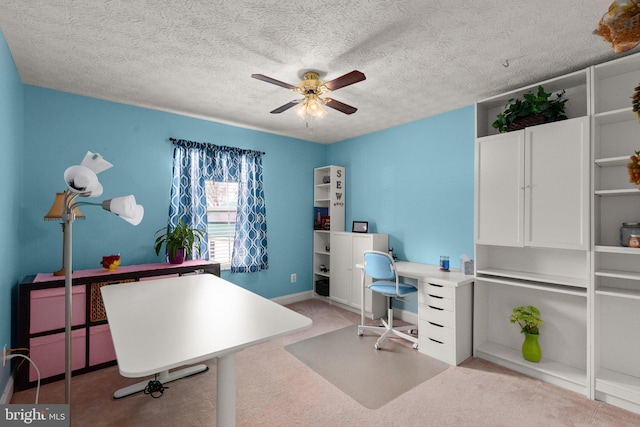 carpeted office space featuring a textured ceiling and ceiling fan