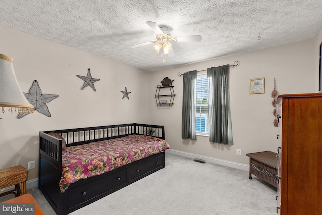 carpeted bedroom with a textured ceiling and ceiling fan