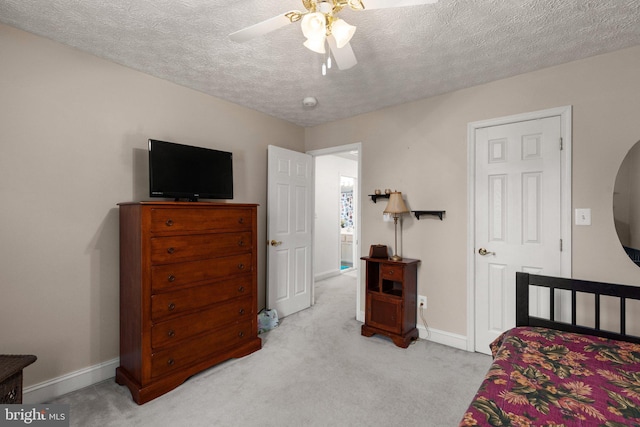 bedroom featuring ceiling fan, light colored carpet, and a textured ceiling