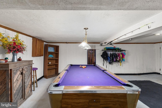 game room featuring wooden walls, ornamental molding, a textured ceiling, and pool table