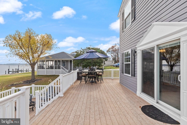 wooden deck featuring a sunroom and a water view