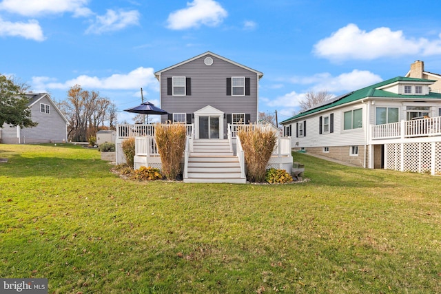 rear view of house featuring a wooden deck and a lawn