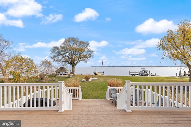 wooden terrace featuring a lawn and a water view