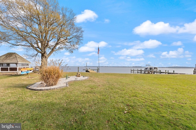 view of yard featuring a water view and a boat dock