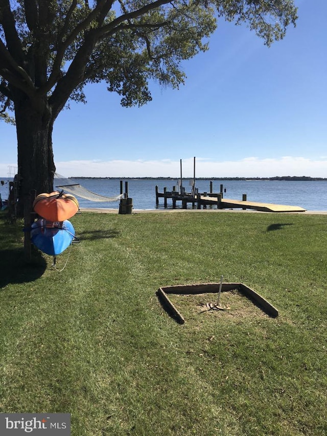 view of home's community featuring a water view, boat lift, a dock, and a yard