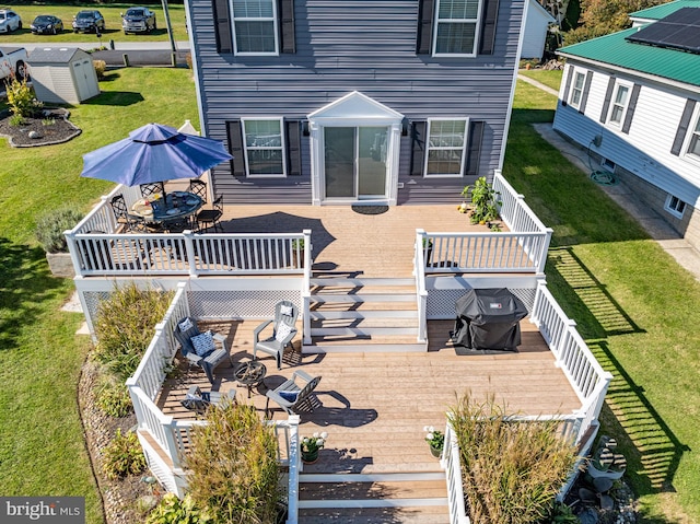 rear view of house featuring a storage shed and a wooden deck