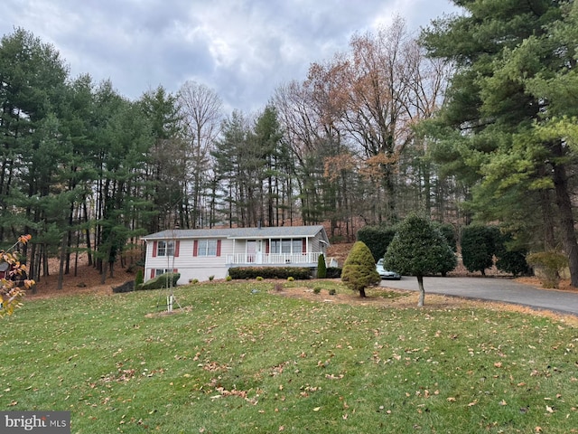 manufactured / mobile home featuring covered porch and a front lawn