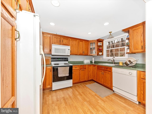 kitchen with white appliances, light hardwood / wood-style floors, and sink