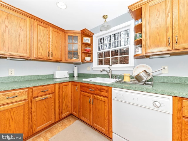 kitchen featuring sink, white dishwasher, and light wood-type flooring