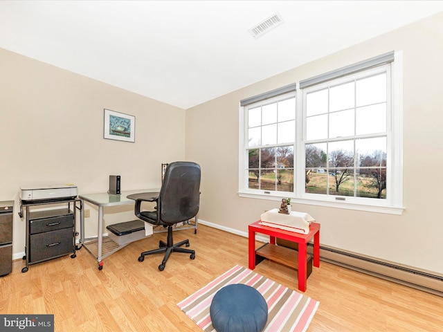 office space with light wood-type flooring and baseboard heating