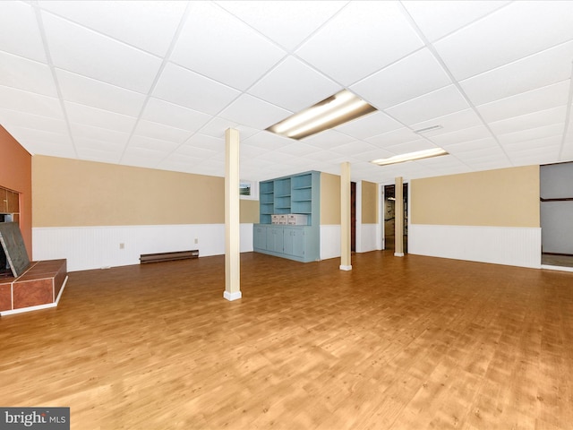 basement with a drop ceiling and wood-type flooring