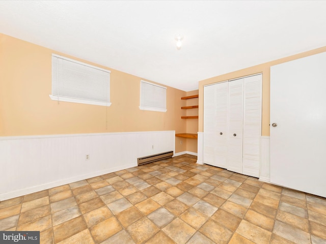 unfurnished bedroom featuring baseboard heating and a closet